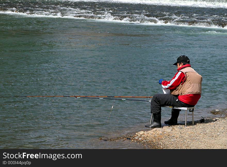 A man fishing on the riverside. A man fishing on the riverside