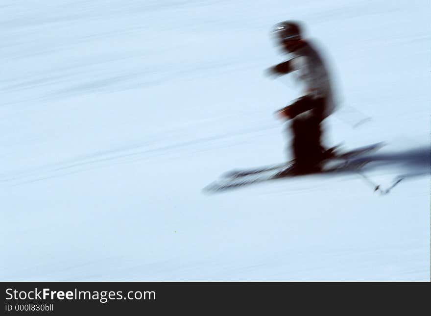 Skier descending a ski slope, highly blurred. Motion panned shot, on Velvia ISO 100, slightly grainy. Skier descending a ski slope, highly blurred. Motion panned shot, on Velvia ISO 100, slightly grainy.