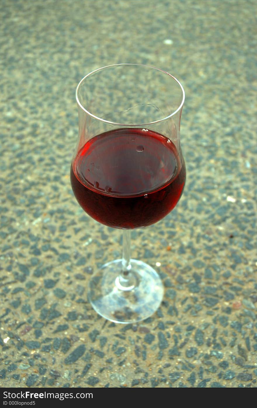 A glass of rose wine on a gravel road. A glass of rose wine on a gravel road