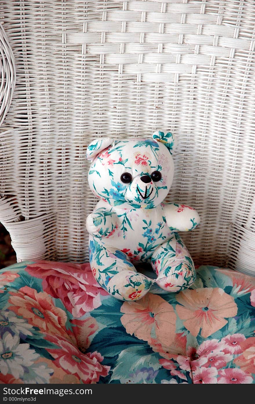 Stuffed bear in wicker chair