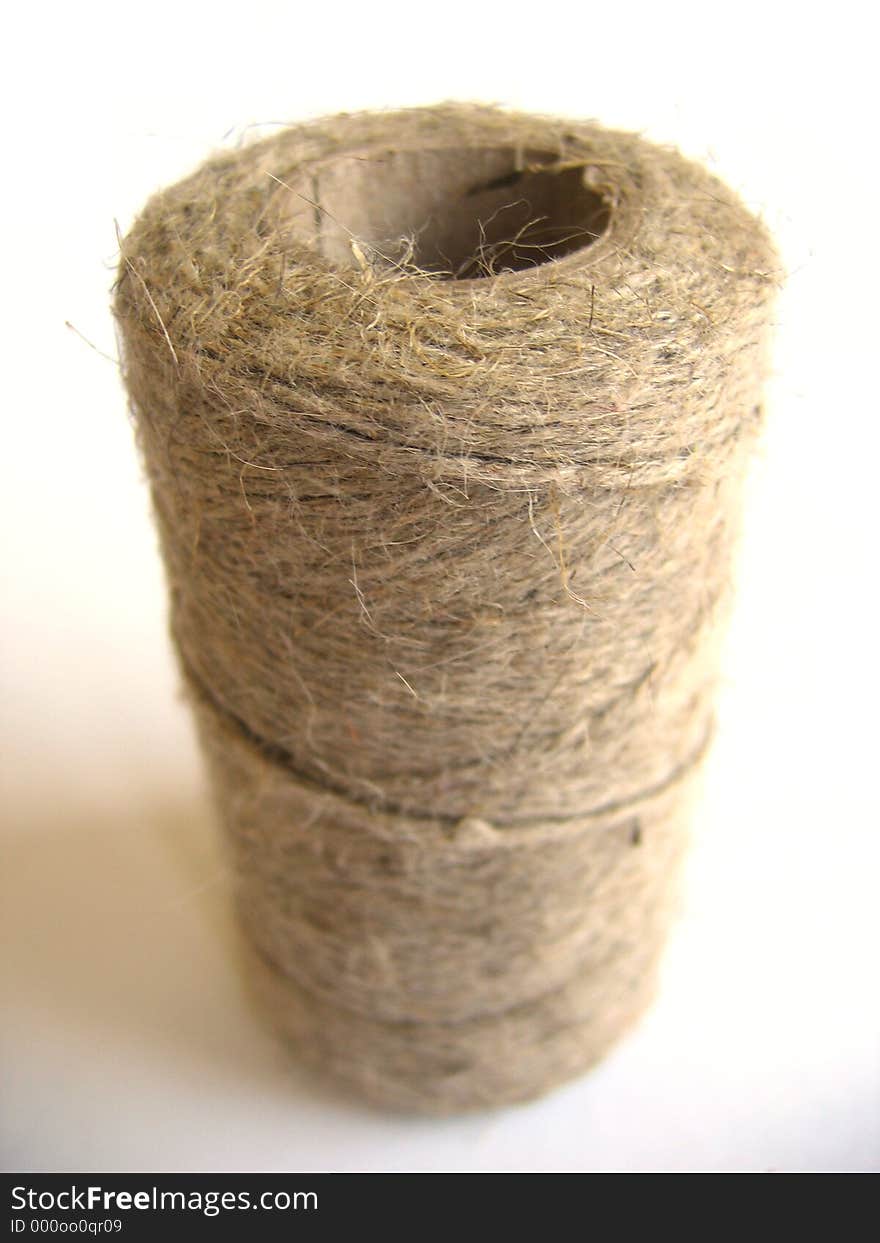 A spool of linen or hemp twine on a white background. A spool of linen or hemp twine on a white background