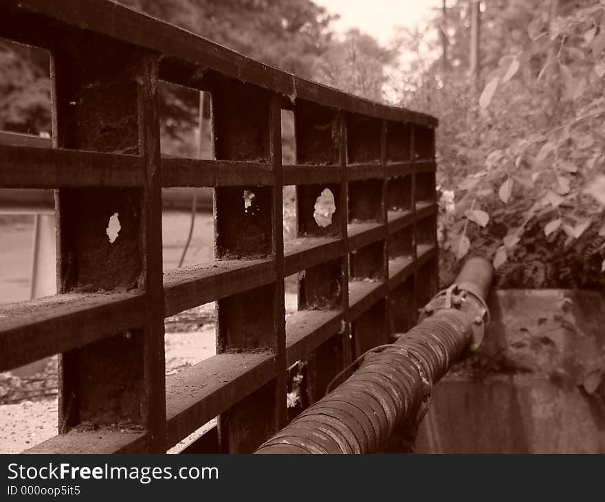 View of old Liberty Street Bridge in Easthampton, Massachusetts, scene shows foliae, holes in bridge, rusted pipe