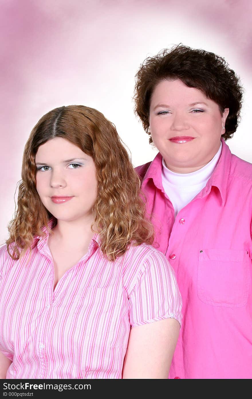 Portrait of mother and teen daughter over pink, wearing pink. Shot with the Canon 20D. Portrait of mother and teen daughter over pink, wearing pink. Shot with the Canon 20D.