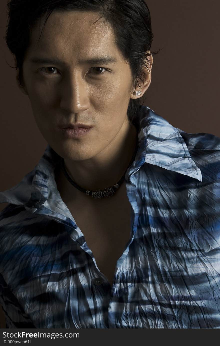 A handsome asian male model in a blue shirt. A handsome asian male model in a blue shirt