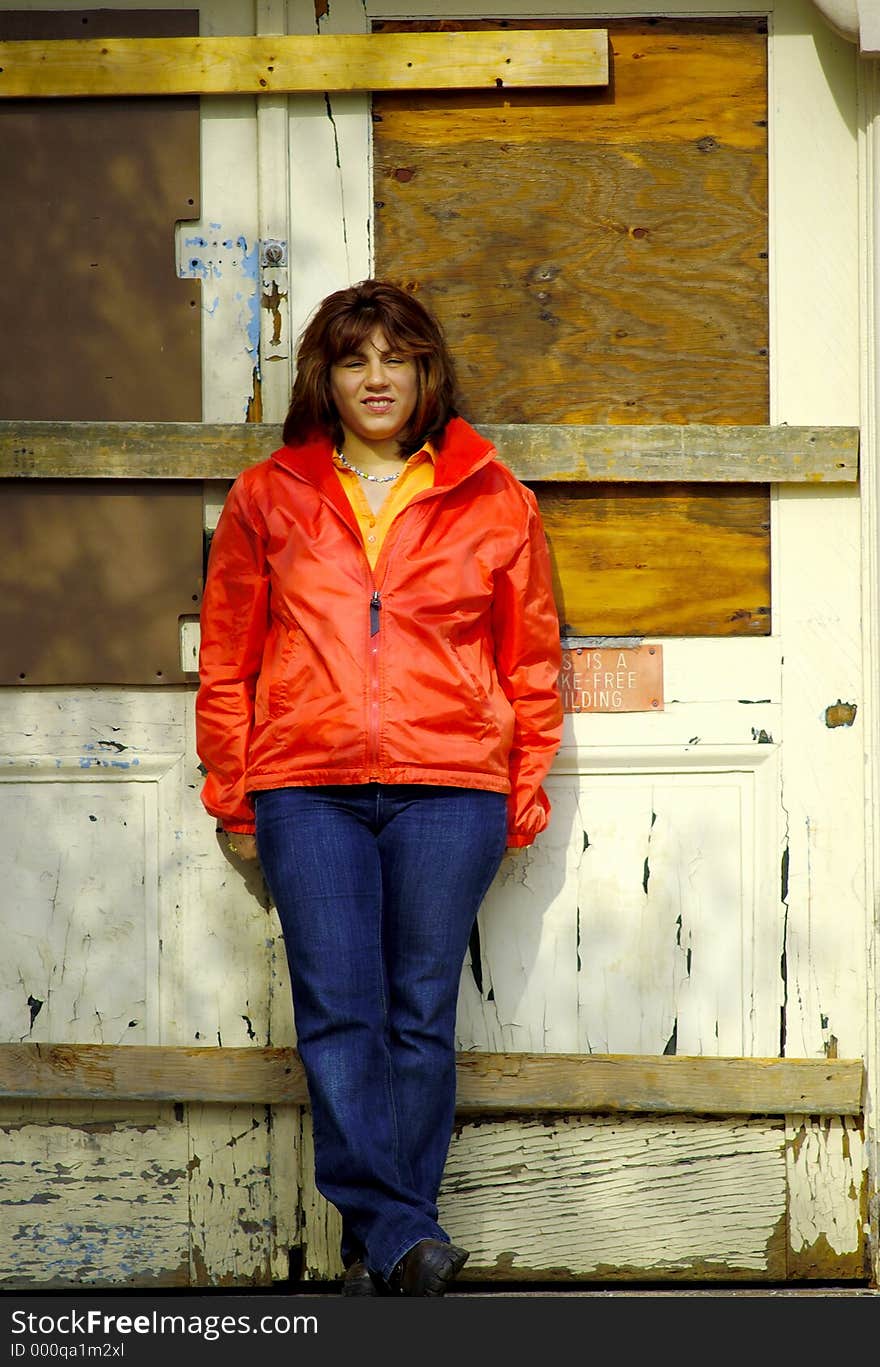 Woman Standing By a Boarded Up Doorway