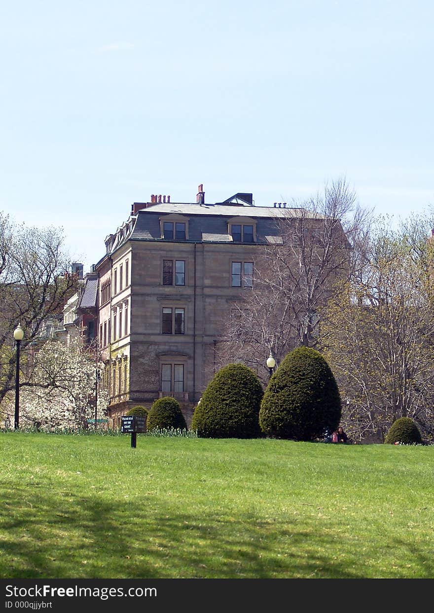 View of old brownstone building from the public gardens in boston massachusetts. keep off the grass sign in early spring. View of old brownstone building from the public gardens in boston massachusetts. keep off the grass sign in early spring