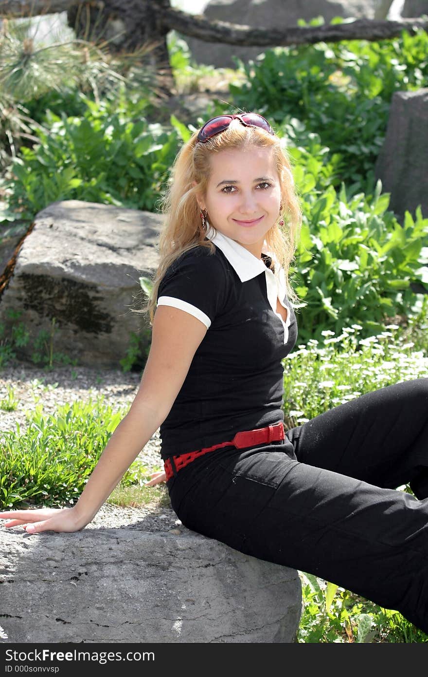 Blond girl sitting in the garden. Blond girl sitting in the garden