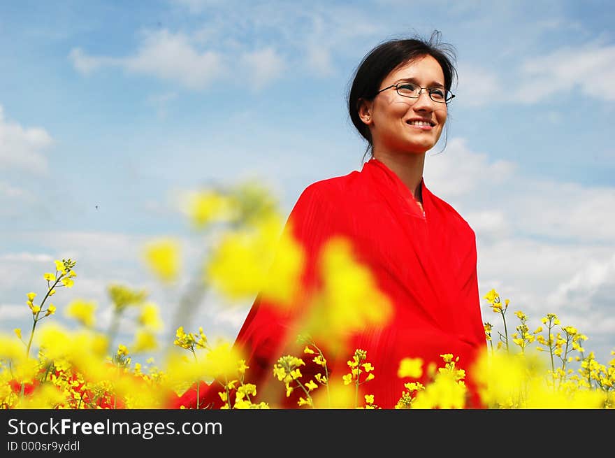 Young girl covered with a long red scarf, in a blury yellow field. great contrast. Young girl covered with a long red scarf, in a blury yellow field. great contrast