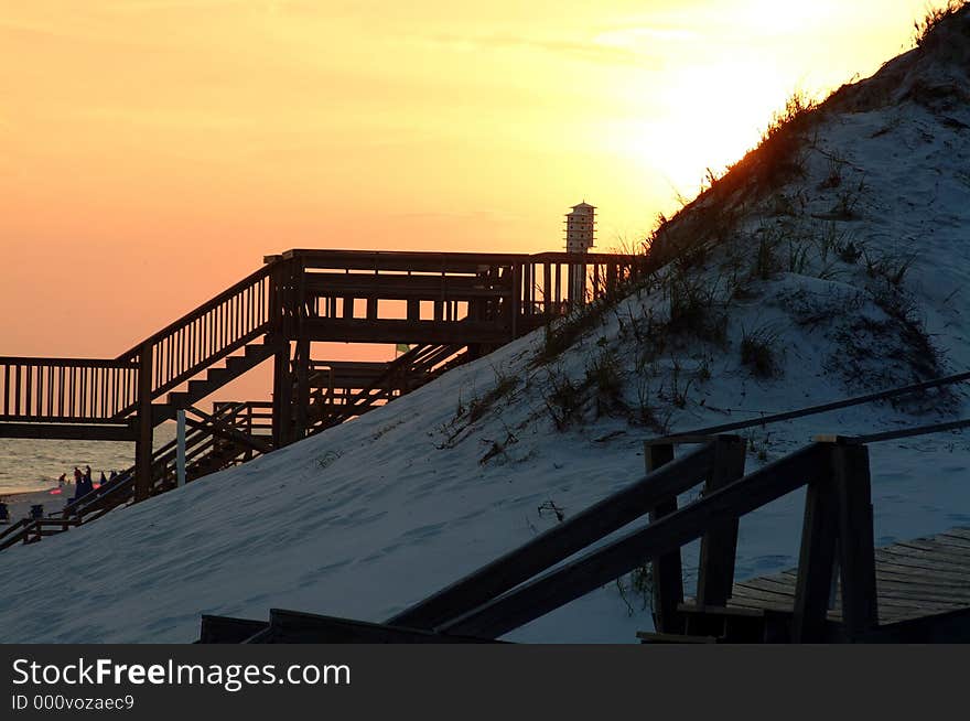 The sun sets over the dunes. A large birdhouse is clearly visible. The sun sets over the dunes. A large birdhouse is clearly visible.