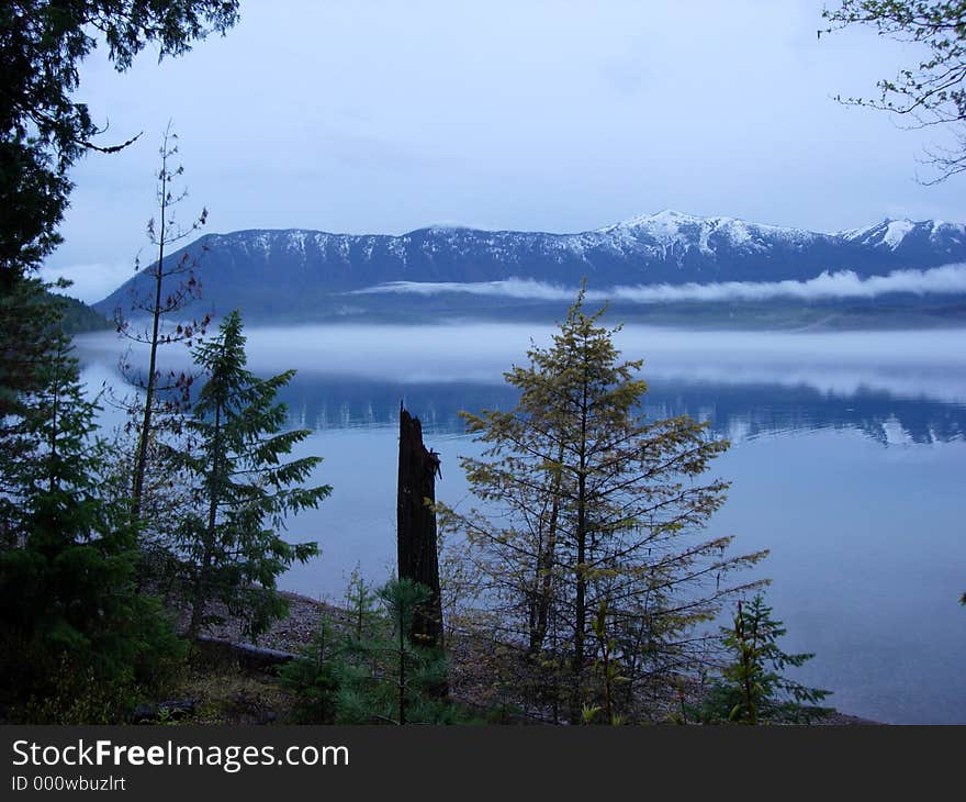 Lake McDonald at dusk in Glacier National Park, with a fog bank rolling over the lake. Lake McDonald at dusk in Glacier National Park, with a fog bank rolling over the lake.