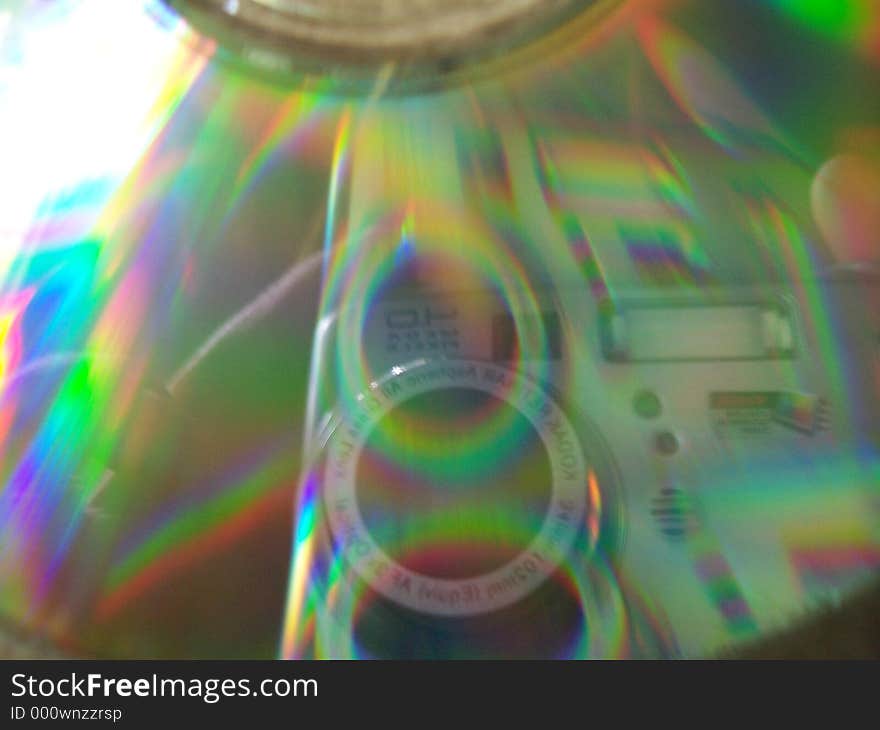 Closeup of a CD with sunlight bouncing off, creating a prism effect.