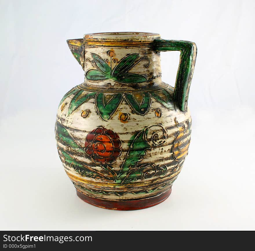 Isolated old jug decorated with colorful leaves and flowers. Isolated old jug decorated with colorful leaves and flowers