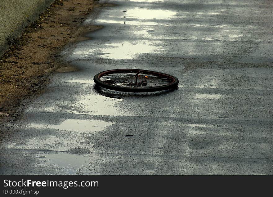 View of an old bike wheel on a roof in a rainy day. View of an old bike wheel on a roof in a rainy day