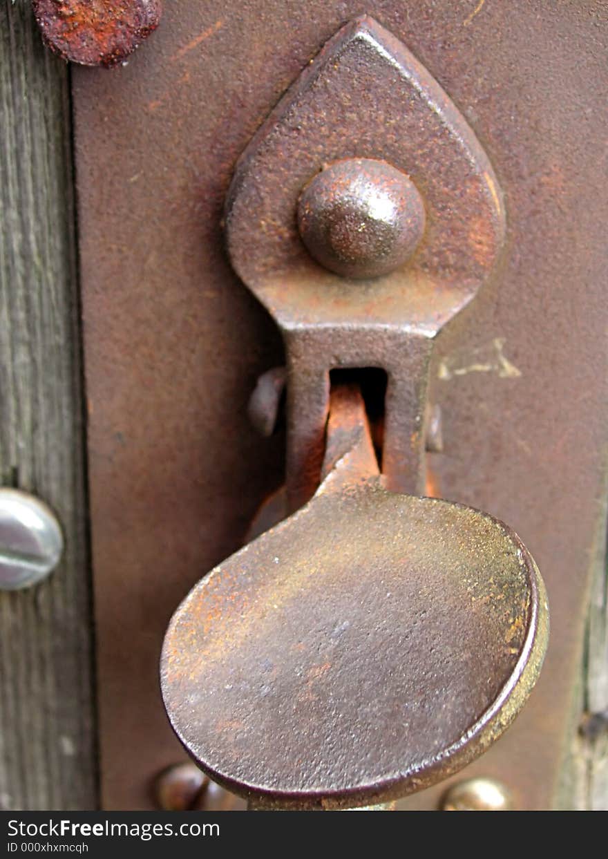 Rusty old gate latch on an old wooden gate