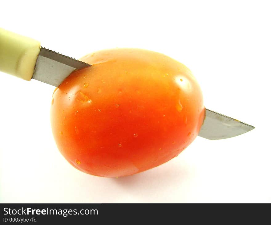 A knife through a tomato. A knife through a tomato