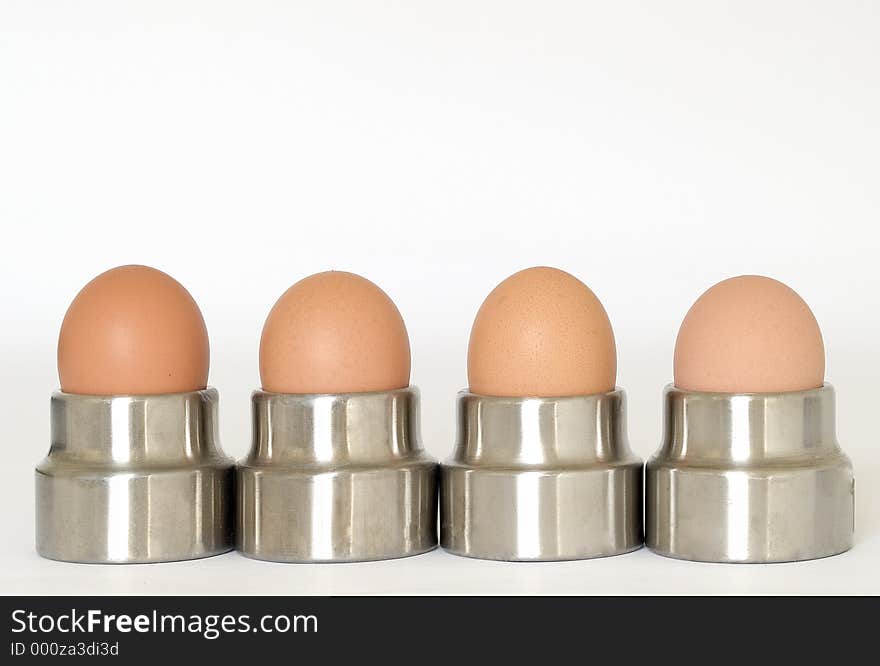 Four eggs in steel egg cups. Four eggs in steel egg cups