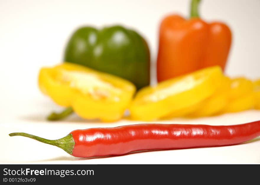 Green, yellow,orange and red paprika on a white background. Green, yellow,orange and red paprika on a white background.