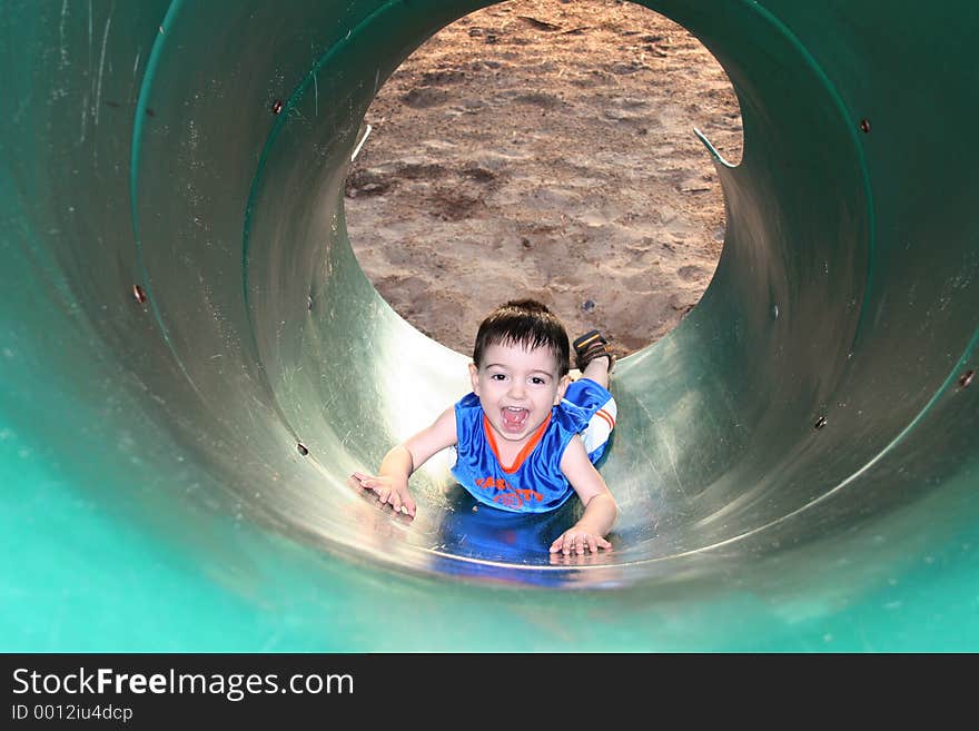 Boy Laughing And Playing With The Slide