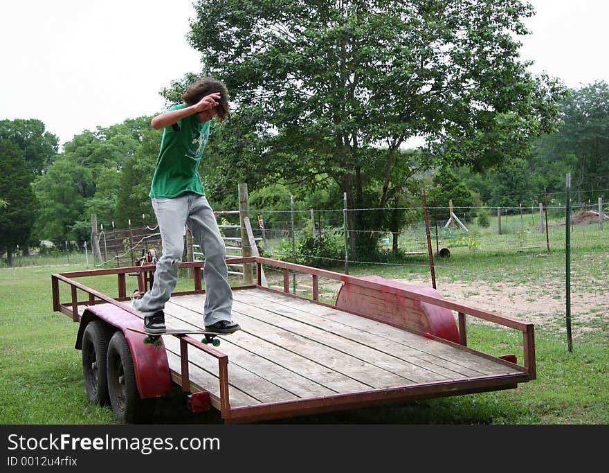 Skateboarder board sliding on trailer rail in his backyard. Shot with Canon 20D. Skateboarder board sliding on trailer rail in his backyard. Shot with Canon 20D.