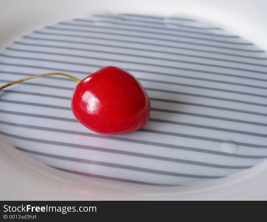 Isolated cherry on a plate. Isolated cherry on a plate