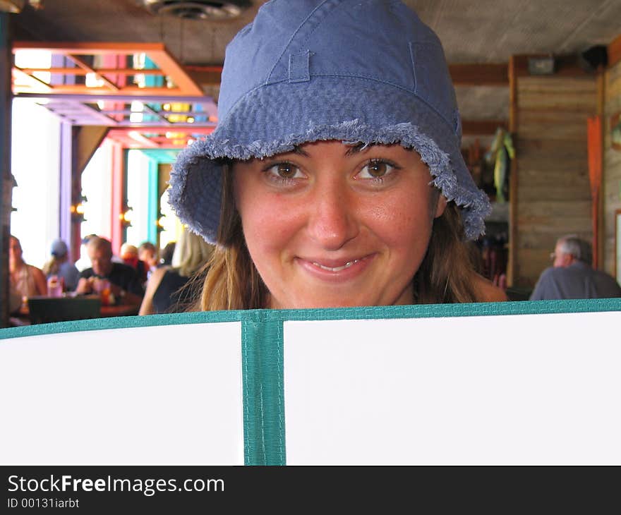 Cute woman at beach restaurant looking at a menu. Cute woman at beach restaurant looking at a menu