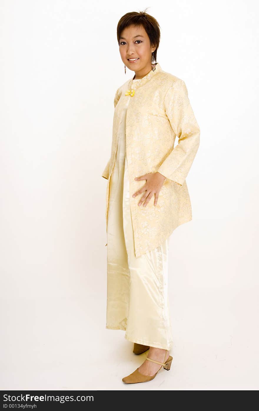 A full length shot of a young Malay woman wearing a traditional yellow jacket and dress. A full length shot of a young Malay woman wearing a traditional yellow jacket and dress