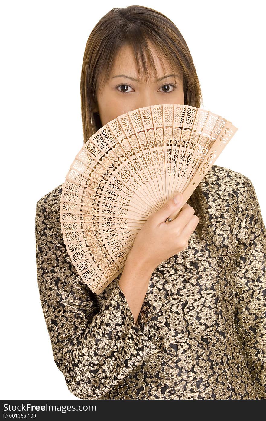 A pretty young asian girl holds a wooden fan in front of her face. A pretty young asian girl holds a wooden fan in front of her face