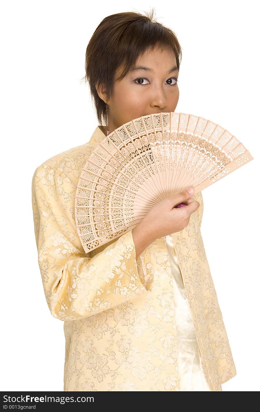 A pretty young asian model wears a yellow jacket and holds a wooden fan. A pretty young asian model wears a yellow jacket and holds a wooden fan