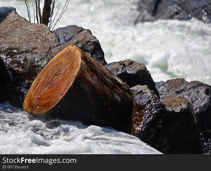 Log stuck in the rocks beyond rapids