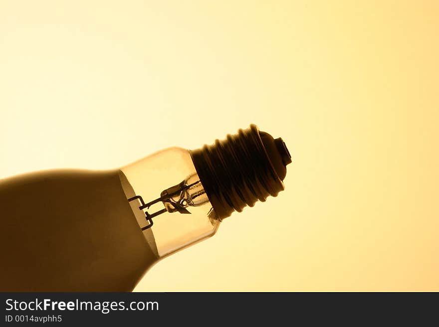 A large thread bulb silhouetted in front of a yellow background. A large thread bulb silhouetted in front of a yellow background