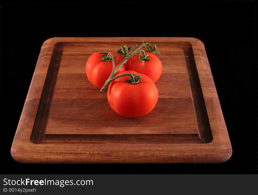 Three Tomatoes on wood cutting board. Three Tomatoes on wood cutting board