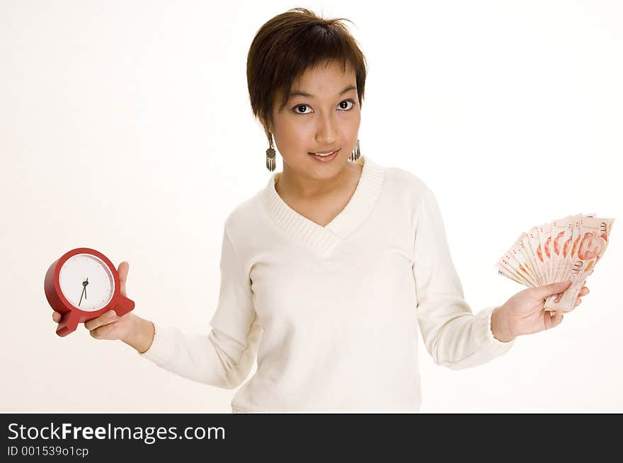 A pretty young asian woman holds a clock and a lot of money. A pretty young asian woman holds a clock and a lot of money