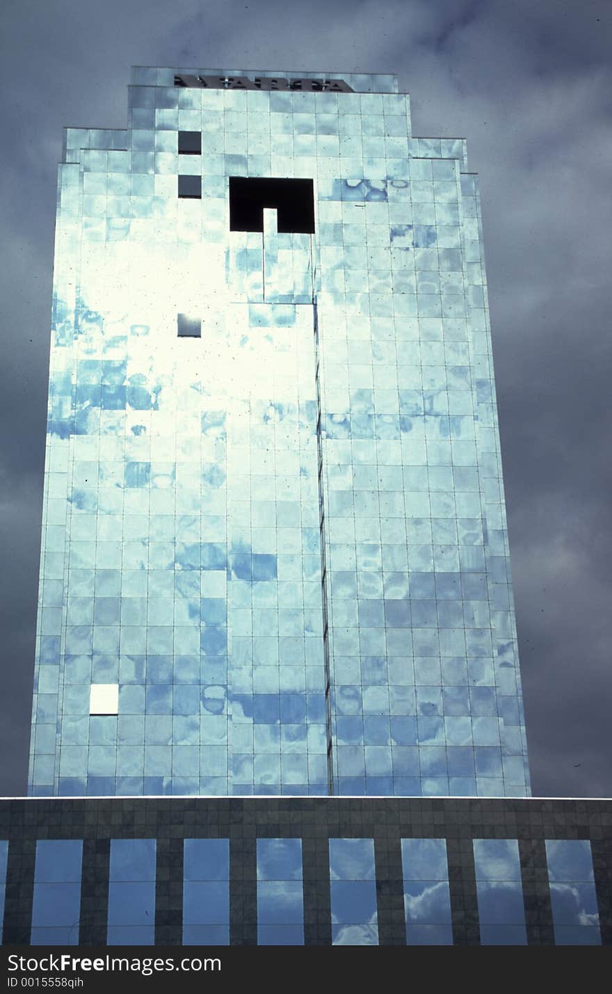 Glass Building with sun and clouds reflection.