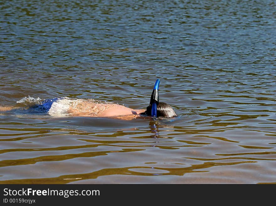 A young boy snorkeling and cooling off on a hot summer day. A young boy snorkeling and cooling off on a hot summer day