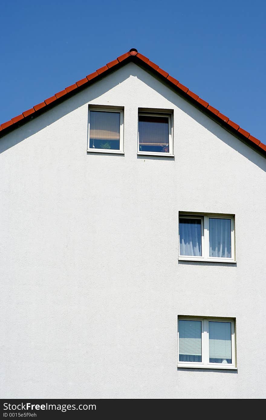 White house with windows in a hot sunny day. Blue sky as background, assymetric windows. White house with windows in a hot sunny day. Blue sky as background, assymetric windows