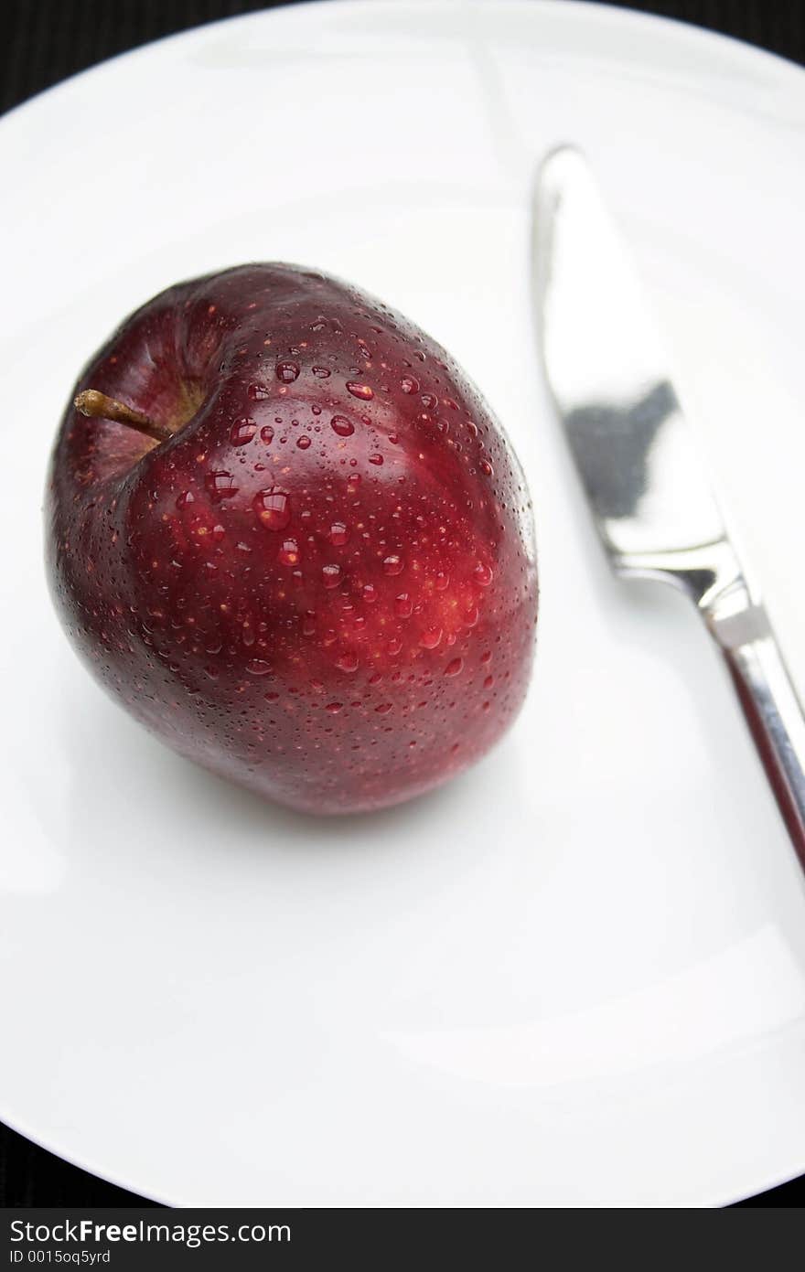 Red apple & knife on a white plate. Red apple & knife on a white plate