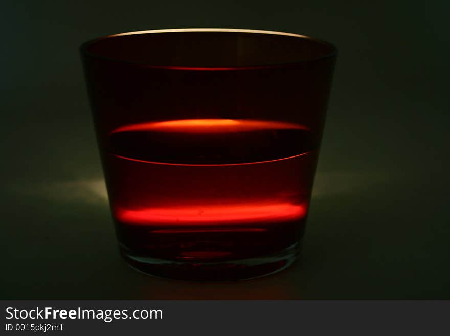 A red coloured glass shot in a lighting condition that has been specially created to make it dramatic. A red coloured glass shot in a lighting condition that has been specially created to make it dramatic