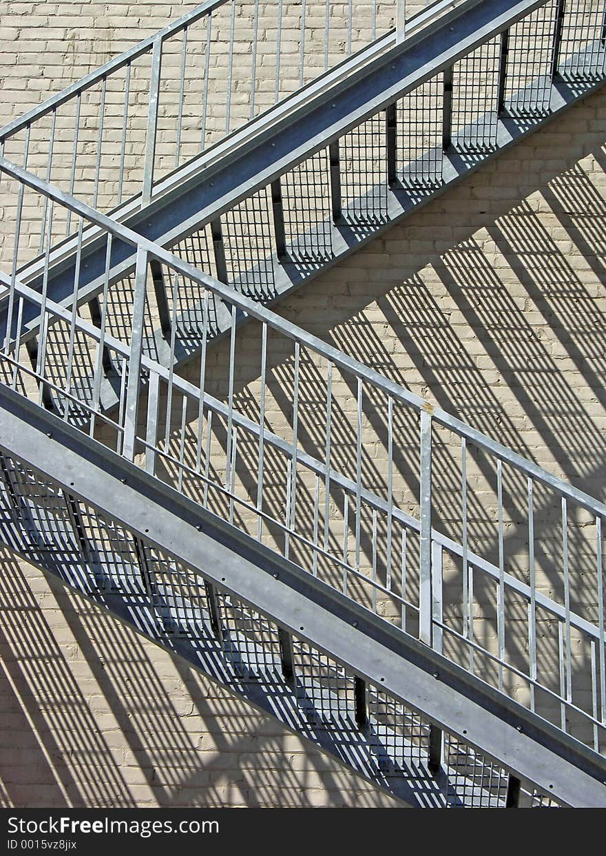 Staircase reflecting on the bricks in the building behind it. Staircase reflecting on the bricks in the building behind it.