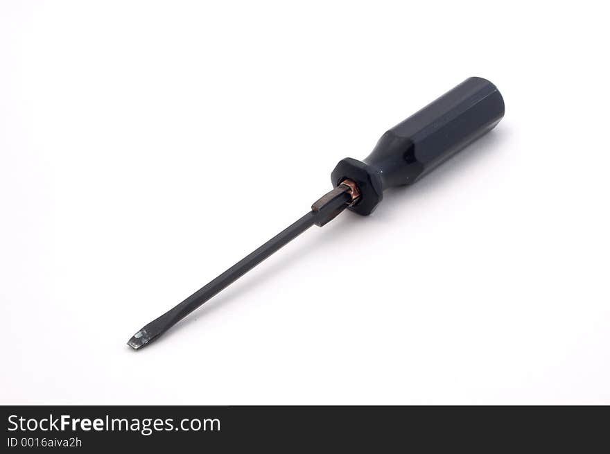 A black flat bladed screwdriver over white, lots of depth of field