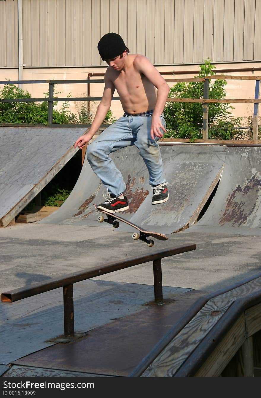 Male teen skateboarder landing across rail. Shot with a Canon 20D. Male teen skateboarder landing across rail. Shot with a Canon 20D.