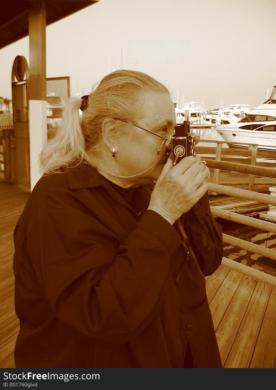 Woman with Mini Camera taking a picture. Woman with Mini Camera taking a picture
