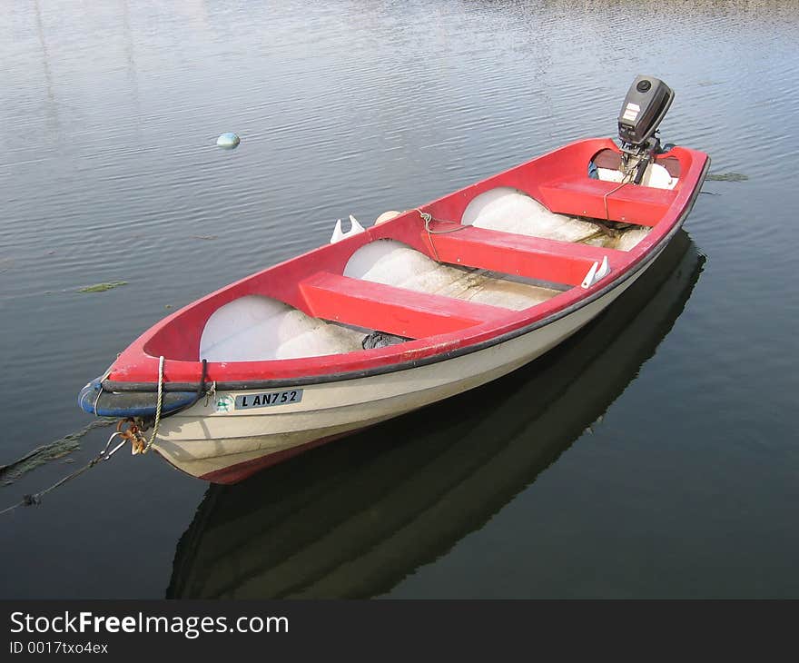 A rowboat in the sea, with an engine. A rowboat in the sea, with an engine.