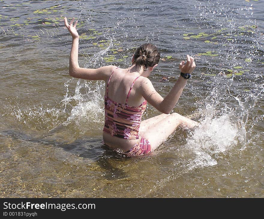 Young girl at the beach having fun to splash water all around. Young girl at the beach having fun to splash water all around