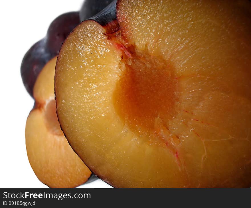 Split black plums in close detail. Split black plums in close detail.