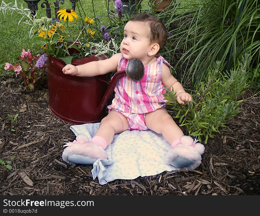 Baby in garden with watering can planter