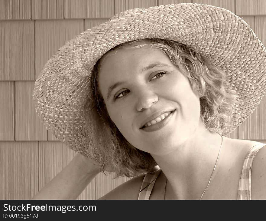 Pretty woman in straw hat; toned for an old-fashioned look. Pretty woman in straw hat; toned for an old-fashioned look