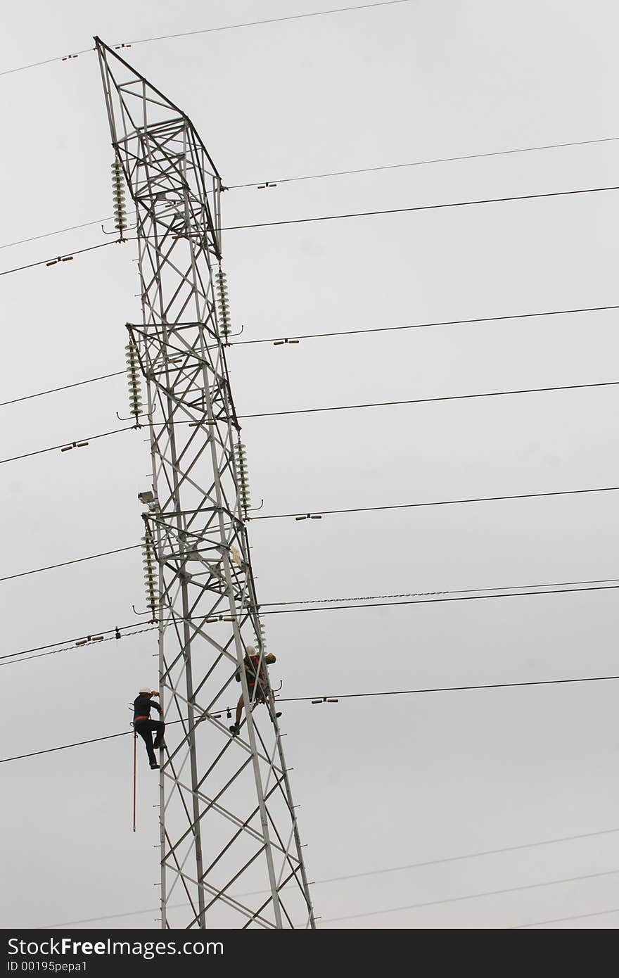 Workers climbing on power pylon