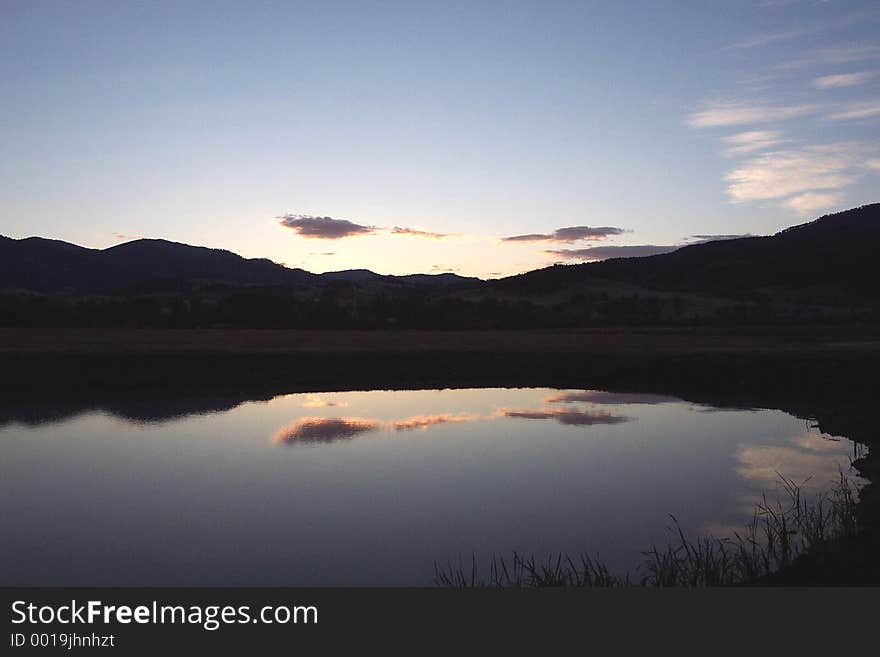 Cloud, sky and mountain reflections in calm water of Hyalite Reservoir. Cloud, sky and mountain reflections in calm water of Hyalite Reservoir.