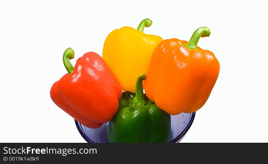 Four peppers (green, red, yellow and orange) in a blue glass bowl. Isolated cleanly on white. Four peppers (green, red, yellow and orange) in a blue glass bowl. Isolated cleanly on white.