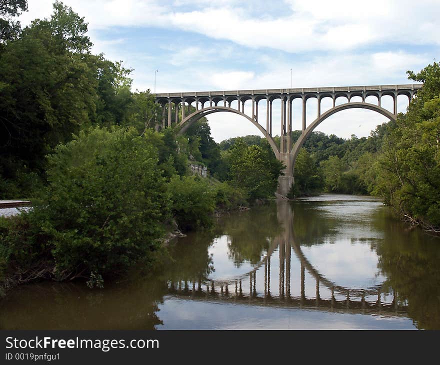 Arched bridge reflected in water below